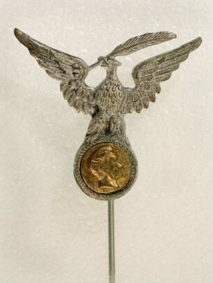 Abzeichen Deutscher Stenographenbund Gabelsberger (mit langer Nadel) : Medaillensammlung Stenografische Sammlung. Abzeichen Deutscher Stenographenbund Gabelsberger (Adler/Reichsadler mit gespreizten Flügeln, eine Feder im Schnabel, auf dem Kopfbildnis Gabelsbergers sitzend, mit langer Nadel). Metall; Maße (ohne Nadel) 28 x 31,5 mm (1900/1926). Dresden: SLUB R c 0379