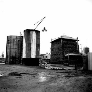 Hochsilos mit Greiferanlage und nebenstehendem überdachten Futterstock