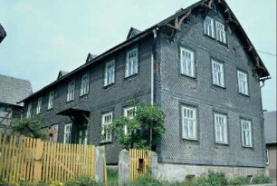 Wohnhaus mit überdachter Haustür, Holzschmuck im Giebel