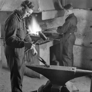 Lehrlinge von Borgward beim Schmieden am Amboss mit Hammer und Zange
