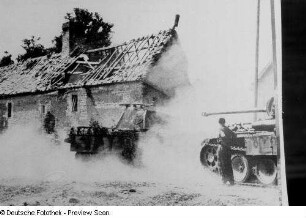 Reproduktion einer Fotografie von einer Gebäuderuine sowie gepanzerten Wehrmachtsfahrzeugen