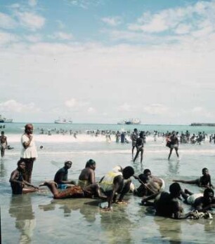 Accra. Ussher Fort : Accra (Ghana). Badende am Strand bei Ussher Fort und auf Reede liegende Frachtschiffe, 26. April 1959