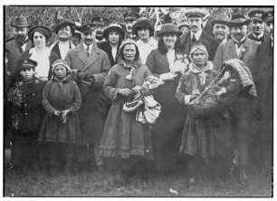 Lappenfrauen. Mädchen, Großmutter (mit Handtaschen) und Mutter (mit Säugling in tragbarer Wiege). Gruppenaufnahme mit Touristen der HAPAG bei Tromsø (Norwegen)