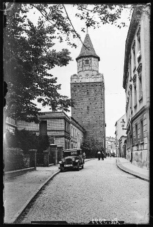 Haynau (poln. Chojnów). Straßenansicht mit Auto und Blick zum Weberturm