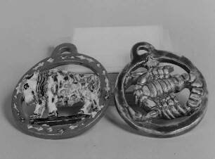 Zwei Medaillons mit Tierkreiszeichen "Stier" und "Krebs" : Zwei Medaillons mit Tierkreiszeichen "Stier" und "Krebs". Irdenware, bemalt, glasiert, ausgeschnittene Muster D. ca. 8,5 cm und D. 10 cm (um 1920; K. Feuerriegel). Museum im Schloß Frohburg V 577/96, V 578/96