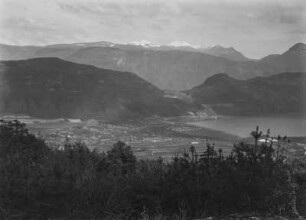 Talblick : Blick in die Ebene mit Kalterer See, Obstbaumwiesen und Leuchtenburg. Im Hintergrund Gebirge