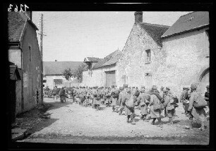 Crugny (Dep. Marne, Frankreich): französische (?) "Gefangene" im Mantel und mit Feldmütze und Marschgepäck auf einer unbefestigten Ortsstraße (Rückansicht)