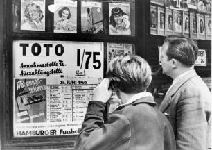 Männer stehen vor der Auslage eines Zeitungskiosk und schauen sich Kitsch-Groschenhefte an