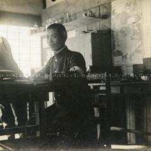 Japanischer Soldat, am Tisch sitzend