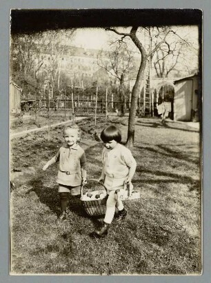 Sachsen. Portrait von zwei Kindern mit einem Korb voller Ostereier in einem Garten