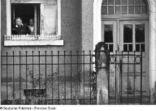 Paar am geöffneten Fenster im Erdgeschoß eines Wohnhauses
