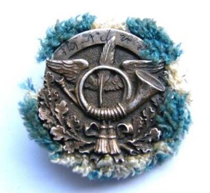 Verdienstabzeichen Gabelsberger-Stenographen-Vereinigung des Postverbandes München mit blau-weißem Wollrand (mit Broschennadel) : Sammlung Beinhorn. Verdienstabzeichen Gabelsberger-Stenographen-Vereinigung des Postverbandes München mit blau-weißem Wollrand (mit Broschennadel). Metall, Wolle; Durchmesser 40 mm (nach 1906; Deschler & Sohn, München). Dresden: SLUB R c 0312