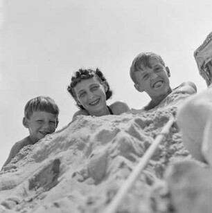 Elisabeth Gremmler, ihr Kind und ein weiterer Junge liegen am Strand