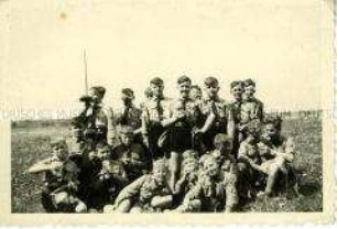 Gruppenbild von Hitlerjungen bei der Brotpause auf einer Wiese
