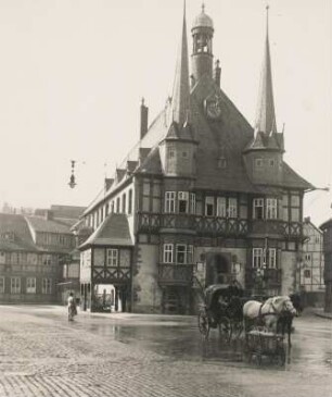 Wernigerode im Harz. Ansicht des, um 1420 im spätgotischen Stil errichteten, Rathauses, im Regen. Davor eine Kutsche