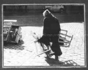 Alte Frau sammelt Marktabfälle