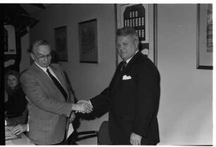 Wahlen von Bürgervorsteher und Stellvertreter von Bürgermeister: Rathaus: Bürgervorsteher Peter Petersen nach Wiederwahl bei Entgegennahme der Gratulation von Mann: hinten an Wand Gemeindewappen