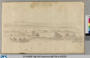 Weite Ebene mit Dorf vor Bergen in der Ferne