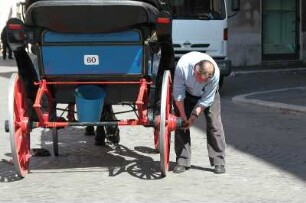 Rom - Fiaker für Touristen : Kutscher repariert an seinem Fiaker in Rom, aufgenommen im April 2004