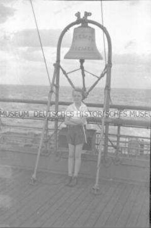 Junges Mädchen unter der Schiffsglocke an Deck des Hochseepassagierdampfers "Bremen"