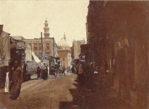 Kairo, Ägypten. Straßenszene in der Altstadt mit Fuhrwerken und geschäftigem Treiben vor Läden