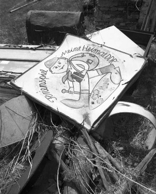 Wandernder Pionier. Blechschild zum Thema "Ferienspiel - Meine Heimat DDR", an einer Bank liegend. Muldenhammer-Tannenbergsthal-Gottesberg, ehemaliges Pionierlager "Hanno Günther"