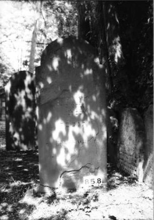 Grabstein 858 (Index: 99630360) Material: Sandstein Zustand: stark abgeblättert mit Textverlust Maße HxBxT: 144x63x8 cm Beschreibung: Stele mit eingezogenem Rundbogenabschluß: Grabstein 858
