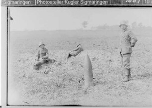 Drei Soldaten mit Granate im Feld