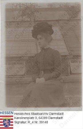 Cronin, Ethel / Porträt, vor Gebäude sitzend, Kniestück / mit dorsaler, handschriftlicher Bildlegende "Miss Ethel Cronin / Patin von Emmy"