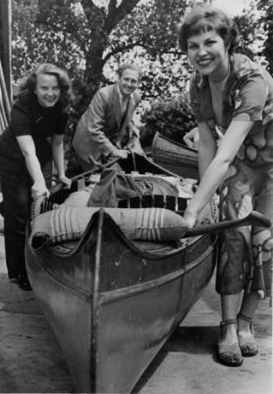 Hamburg - Poppenbüttel. Paddler tragen ihr Boot an der Poppenbüttler Schleuse über Land. Eine schwere Angelegenheit