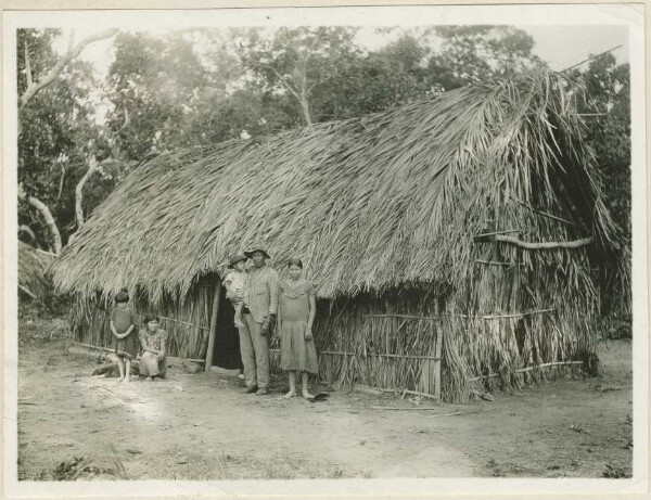 Bakairi Indians in front of a hut