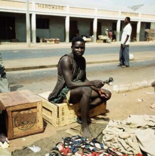 Straßenhändler, Accra : Accra (Ghana). Straßenhändler bietet Schuhe zum Verkauf, 22. Februar 1959