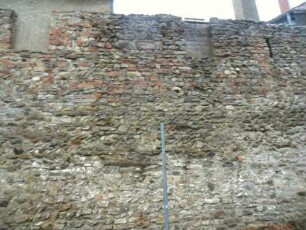 Stadtbefestigung-Stadtmauer (um 1220) im Westen über Feldseite (teilrekonstruiert) mit Steinbrüstung und Schießscharten sowie Werksteinen im Mauersteinverband (teils Opus Spicatum)