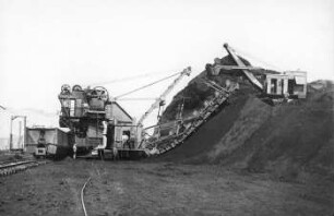 Baggerung im Hochschnitt Tagebau II der Regiser Kohlenwerke mit Eimerketten und Diesellöffelbagger und Großraumzug.