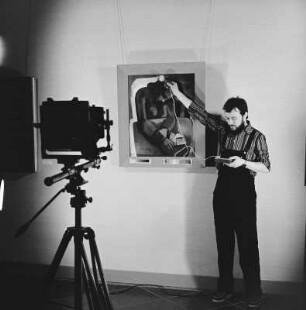 Fotograf der Deutschen Fotothek in der Gemäldegalerie Neue Meister : Der Fotograf der Deutschen Fotothek, André Rous, bei Aufnahmevorbereitungen in der Gemäldegalerie Neue Meister der Staatlichen Kunstsammlungen Dresden. Ausleuchtungskontrolle, Lichtstärkemessung mit einem Luxmeter am Gemälde "Mädchen in Rot mit Brief" (H. Strempel, 1948; Gal.-Nr. 2803)