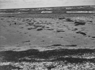 Strand : Blick über den Strand auf das Meer mit Brandungswellen.