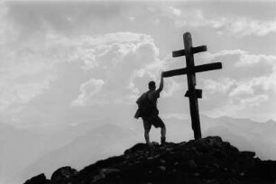 Portrait : Portrait eines Mannes vor einem Gipfelkreuz.