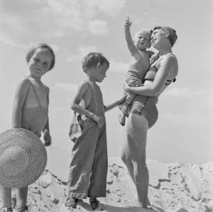 Elisabeth Gremmler hält am Strand ein Kind im Arm, daneben ihr Kind und ein Mädchen