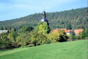 Blick auf die Kirchturmspitze und rote Ziegeldächer