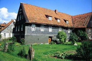denkmalgeschütztes Bauernhaus, Gesamtansicht mit Garten, hinten Scheune