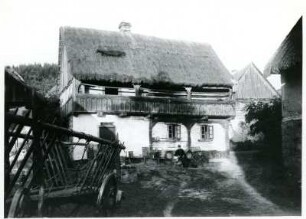 Nordböhmen (tschechisch: Severní Čechy), Hofansicht eines Bauernhauses mit Strohdach und hölzerner Galerie