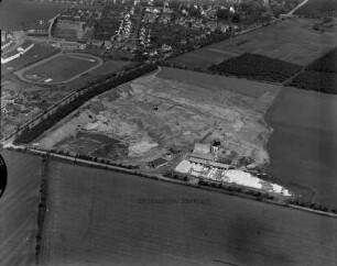 Kalksandsteinwerk Stüwe & Co. (Am Sportplatz 40): Luftbild: links Haidkrugchaussee, im Hintergrund Grundschule mit Sportplatz und Wohngebiet Rosenweg