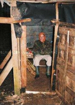 Junge in einer selbstgebauten Holzhütte (Sonderthema: Lebenskunst und Lebenskünstler)