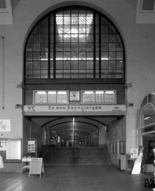 Bahnhof Dresden-Neustadt. Empfangsgebäude, Schalterhalle. Nördlicher Bahnsteigtunnel, über dem Zugang Fahrtrichtungsanzeiger mit Normaluhr und Bogenfenster zur Bahnsteighalle : Dresden-Neustadt, Schlesischer Platz 1. Bahnhof Dresden-Neustadt. Empfangsgebäude, Schalterhalle. Nördlicher Bahnsteigtunnel, über dem Zugang Fahrtrichtungsanzeiger mit Normaluhr und Bogenfenster zur Bahnsteighalle