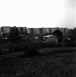 Schanzenbarg: Wohnblocks vor Fertigstellung: rechts Gebäude: in der Mitte unbefestigtes Gelände mit Bauwagen und Baumaterial: vorn Wiese und Zaun