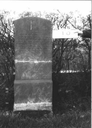 Grabstein 10 (Index: 99808573) Material: Sandstein Zustand: zerbrochen und repariert Maße HxBxT: 143x51x13 cm Beschreibung: Stele, getreppter Sockel, Segmentbogenabschluss mit Ohren Symbolik: vielzackiger Stern: Grabstein 10
