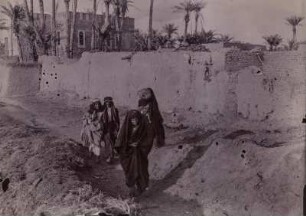 Bei Babylon : Vier Personen vor einer Mauer in der Nähe der Ausgrabungsstelle von Babylon.