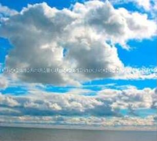 Blauer Himmel mit weißen Wolken über Wasser (Altersgruppe bis 14)