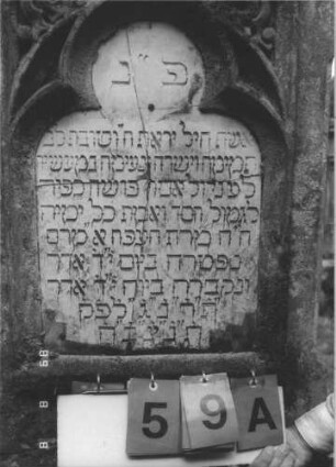 Grabstein 59 (Index: 99799525) Material: Sandstein, Schriftplatte Marmor Zustand: verwittert, Schriftplatte zerbrochen Maße HxBxT: 171x65x25 cm Beschreibung: Stele, Mittelerhöhung, Abdeckplatte, Zinnenaufsätze, Schriftplatte eingelassen mit Kleeblattabschluß, Sockel Symbolik: floral Besonderheit: vermutlich die Gattin von Marx Bloch, Vorsteher, Grabsteinnummer 58: Grabstein 59A