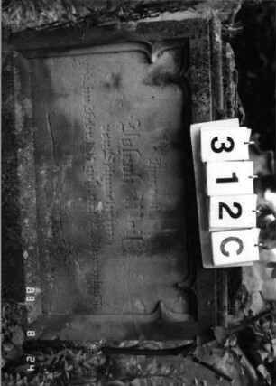 Grabstein 312 (Index: 100095691) Maße HxBxT: 250x53x21 cm Symbolik: Beschneidungsmesser, aufgeschlagenes Buch Besonderheit: kulturhistorisch wertvoll / hist.-wiss. Gründe (Gemeindestellung): Grabstein 312C